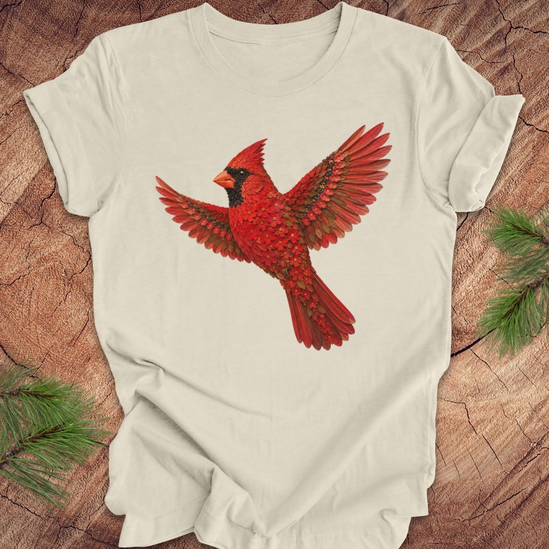Beige t-shirt with a cardinal made of flowers on a wood background.