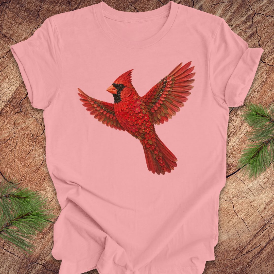 Pink t-shirt with a cardinal made of flowers on a wood background.