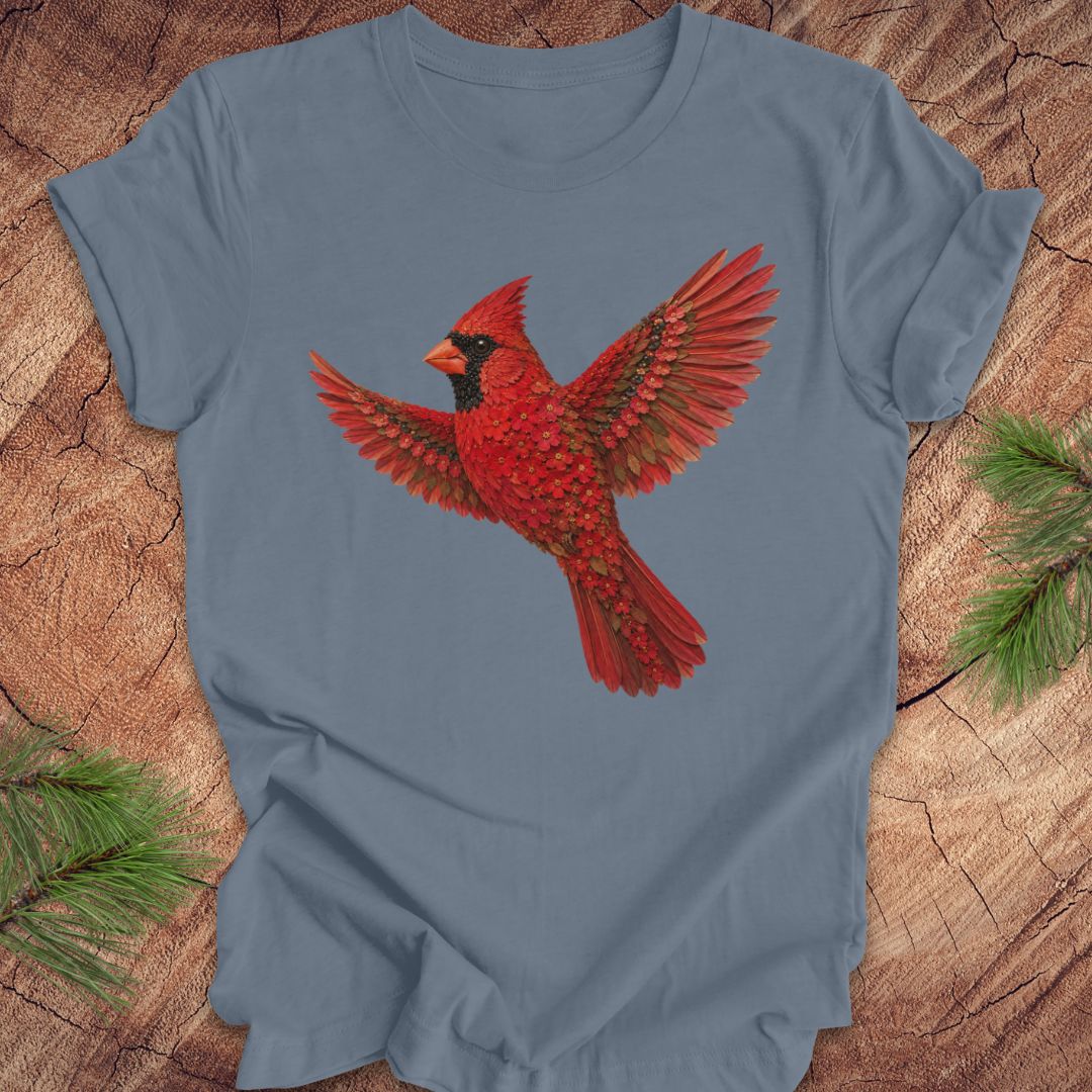 Blue t-shirt with a cardinal made of flowers on a wood background.