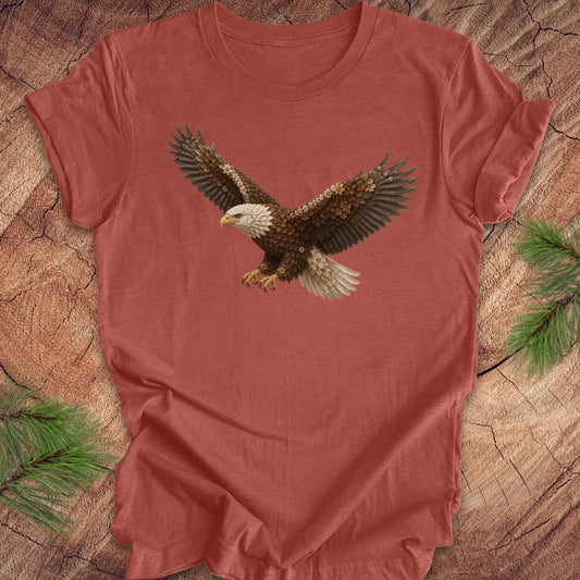 Clay colored t-shirt with an eagle made of flowers on a wood background.