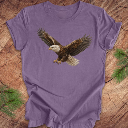 Purple t-shirt with an eagle made of flowers on a wood background.