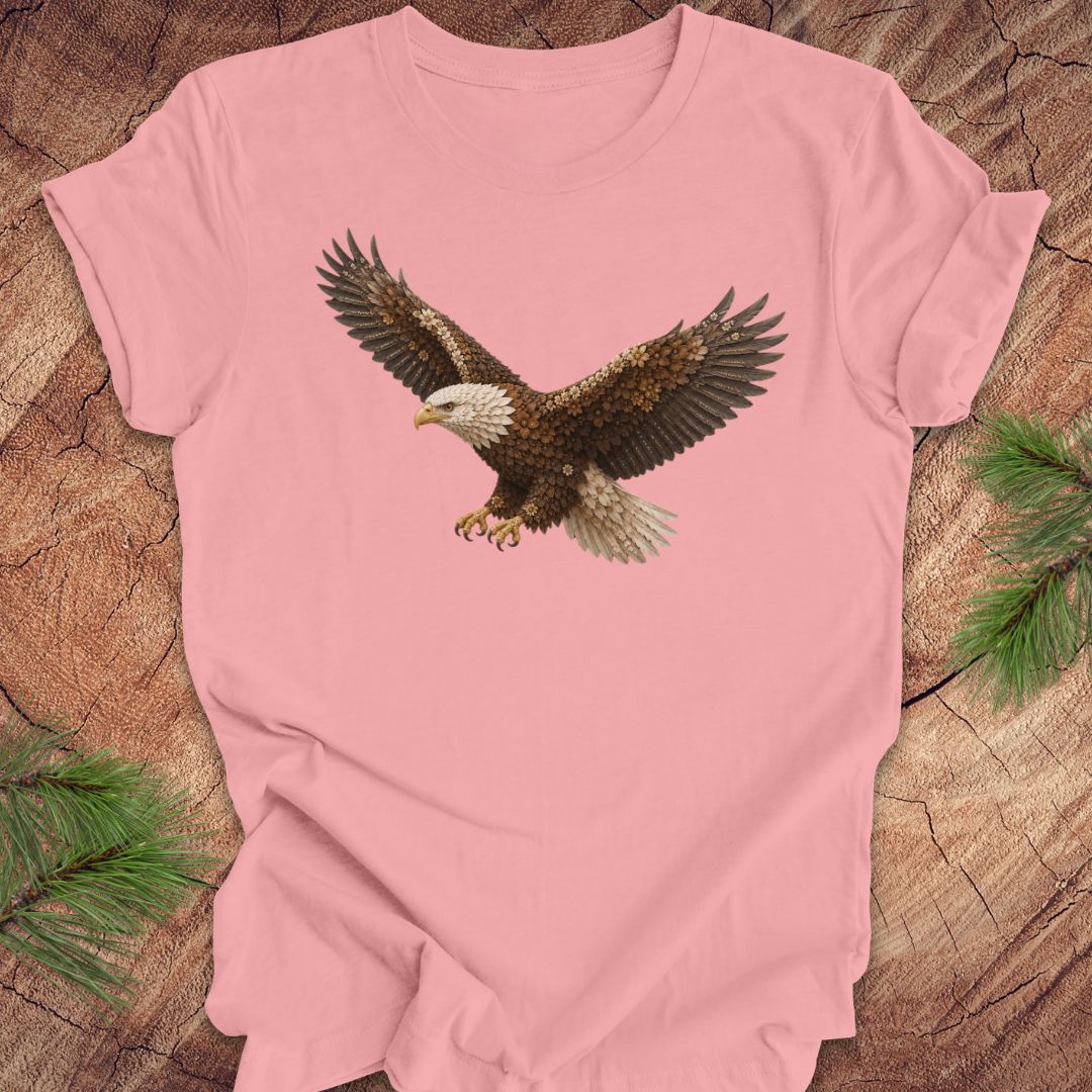 Pink t-shirt with an eagle made of flowers on a wood background.