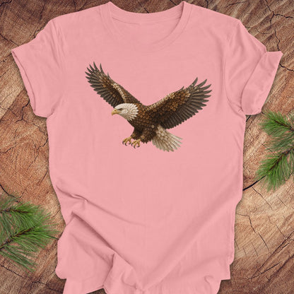Pink t-shirt with an eagle made of flowers on a wood background.