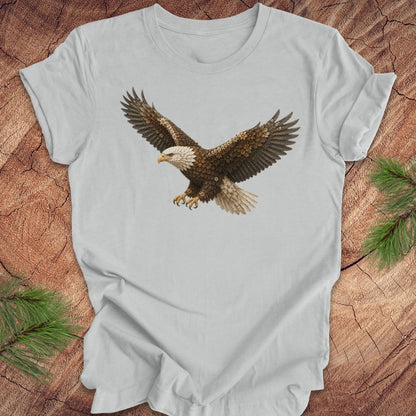 Gray t-shirt with an eagle made of flowers on a wood background.
