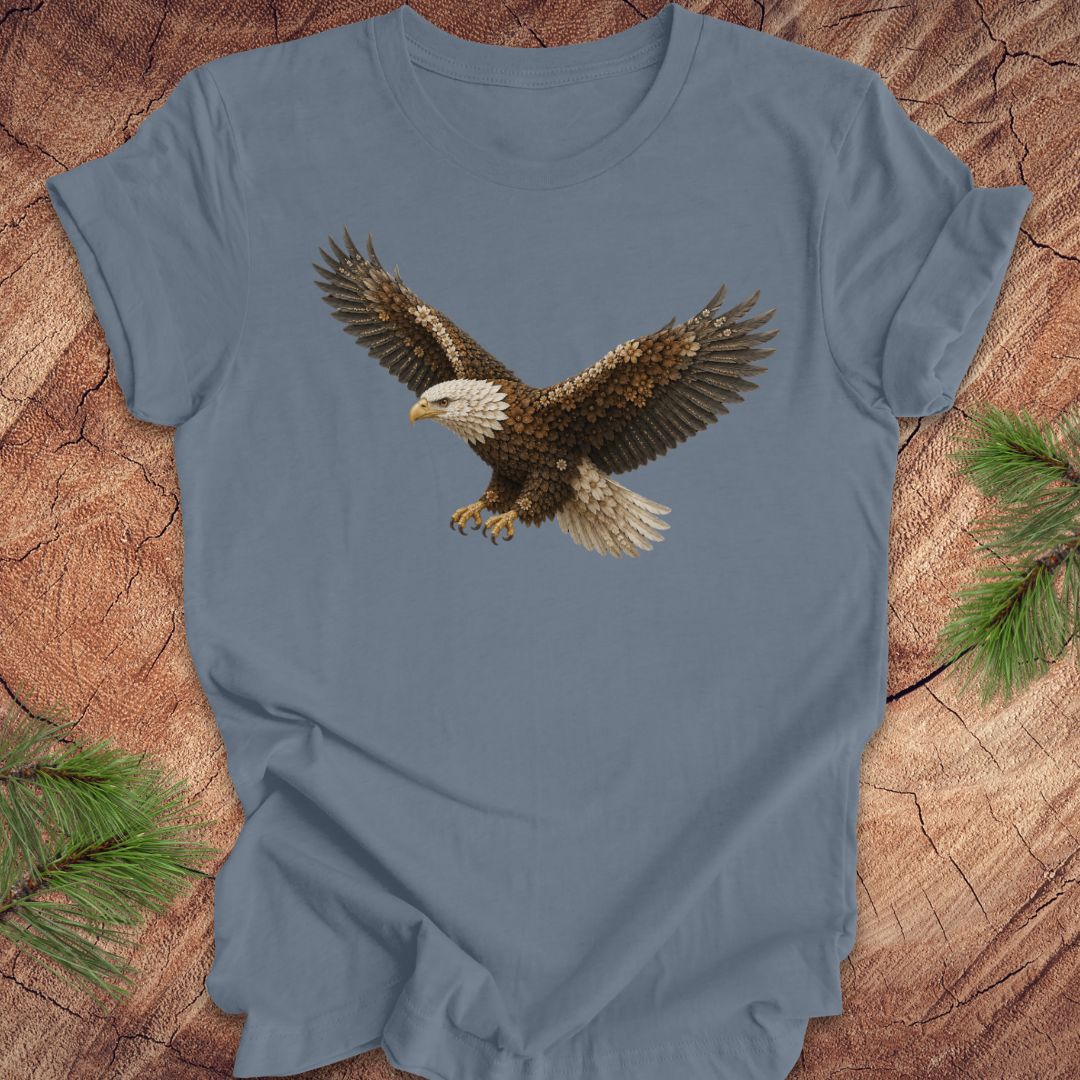 Blue t-shirt with an eagle made of flowers on a wood background.