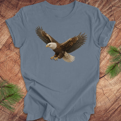 Blue t-shirt with an eagle made of flowers on a wood background.