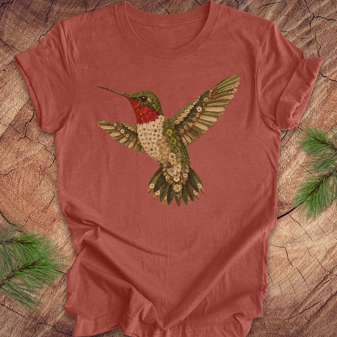 Clay colored t-shirt with a hummingbird and flower design on a wooden surface