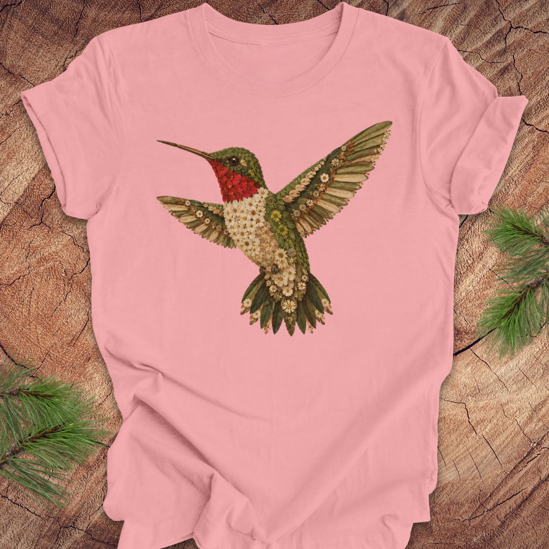  Pink t-shirt with a hummingbird and flower design on a wooden surface.