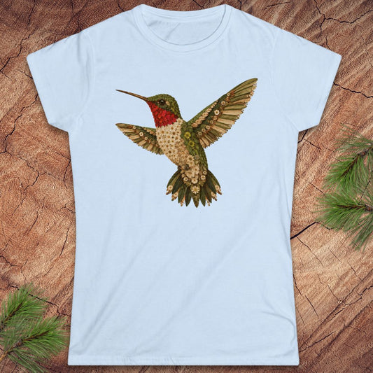 Blue t-shirt with a hummingbird made of flowers on a wood background. 