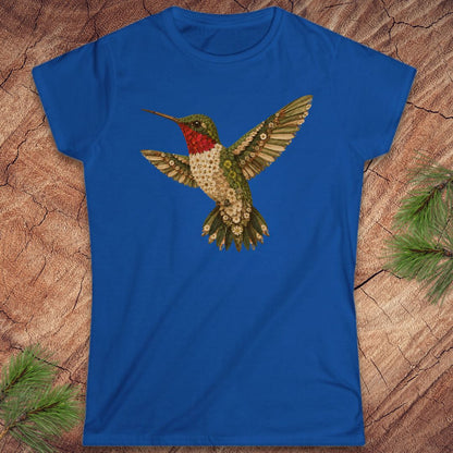 Blue t-shirt with a hummingbird made of flowers on a wood background.