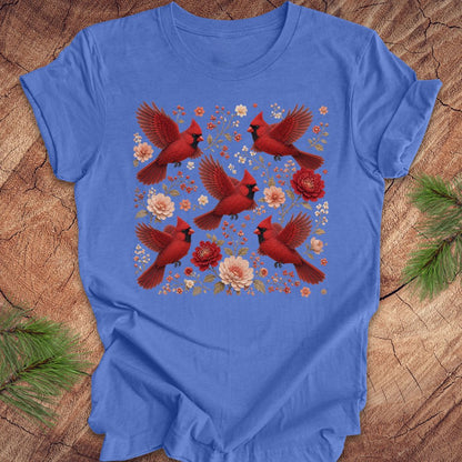 Blue t-shirt with cardinals and flowers on a wood background.
