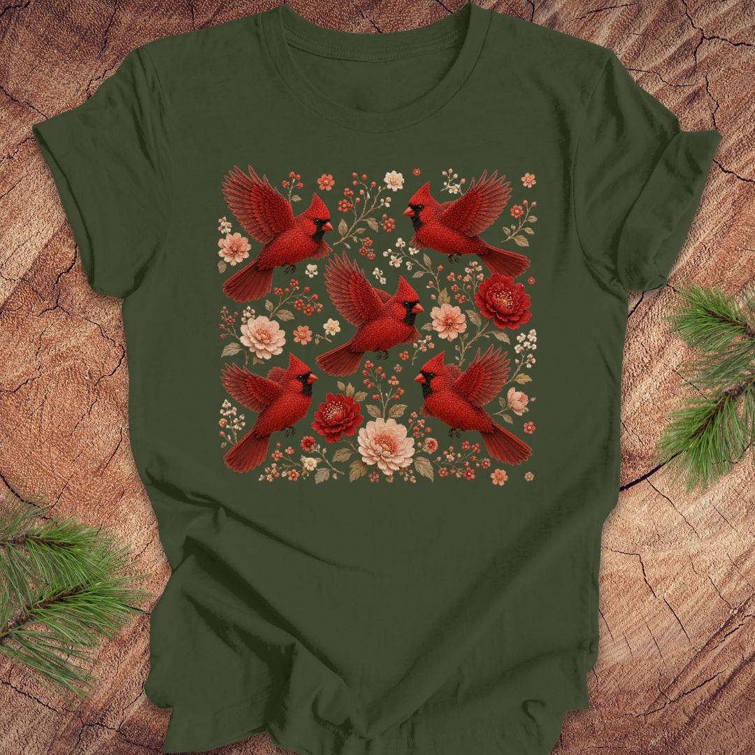 Green t-shirt with cardinals and flowers on a wood background.