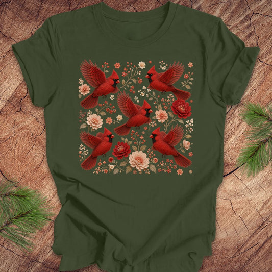 Green t-shirt with cardinals and flowers on a wood background.