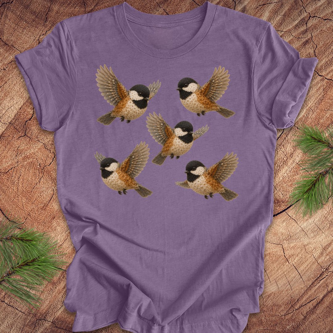 Purple t-shirt with 5 flower chickadees on a wood background.