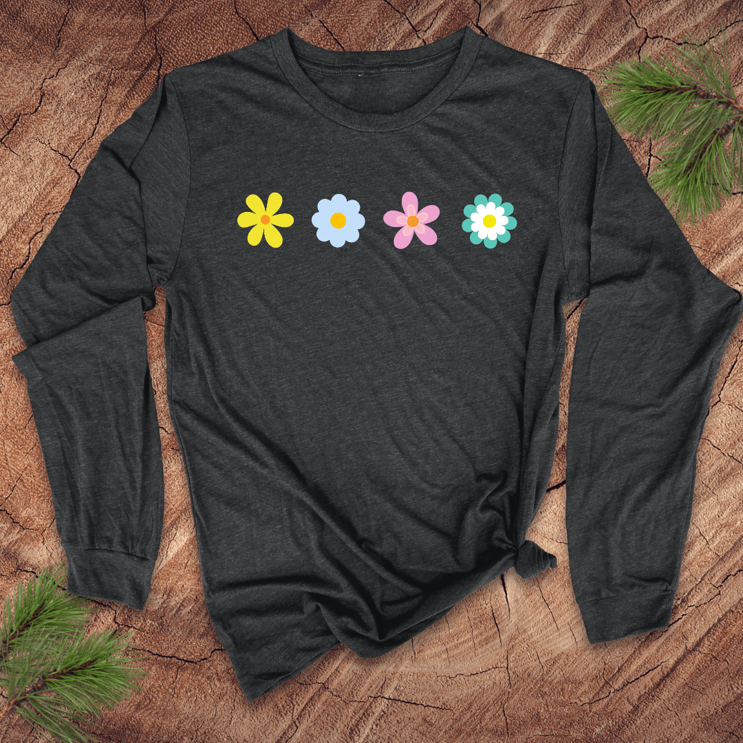 A dark gray long-sleeve shirt with colorful flower designs on a wooden surface with pine branches