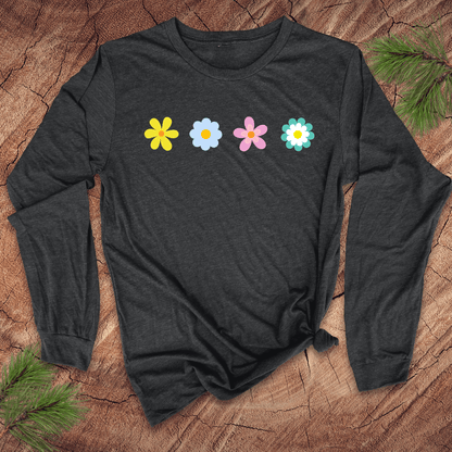 A dark gray long-sleeve shirt with colorful flower designs on a wooden surface with pine branches