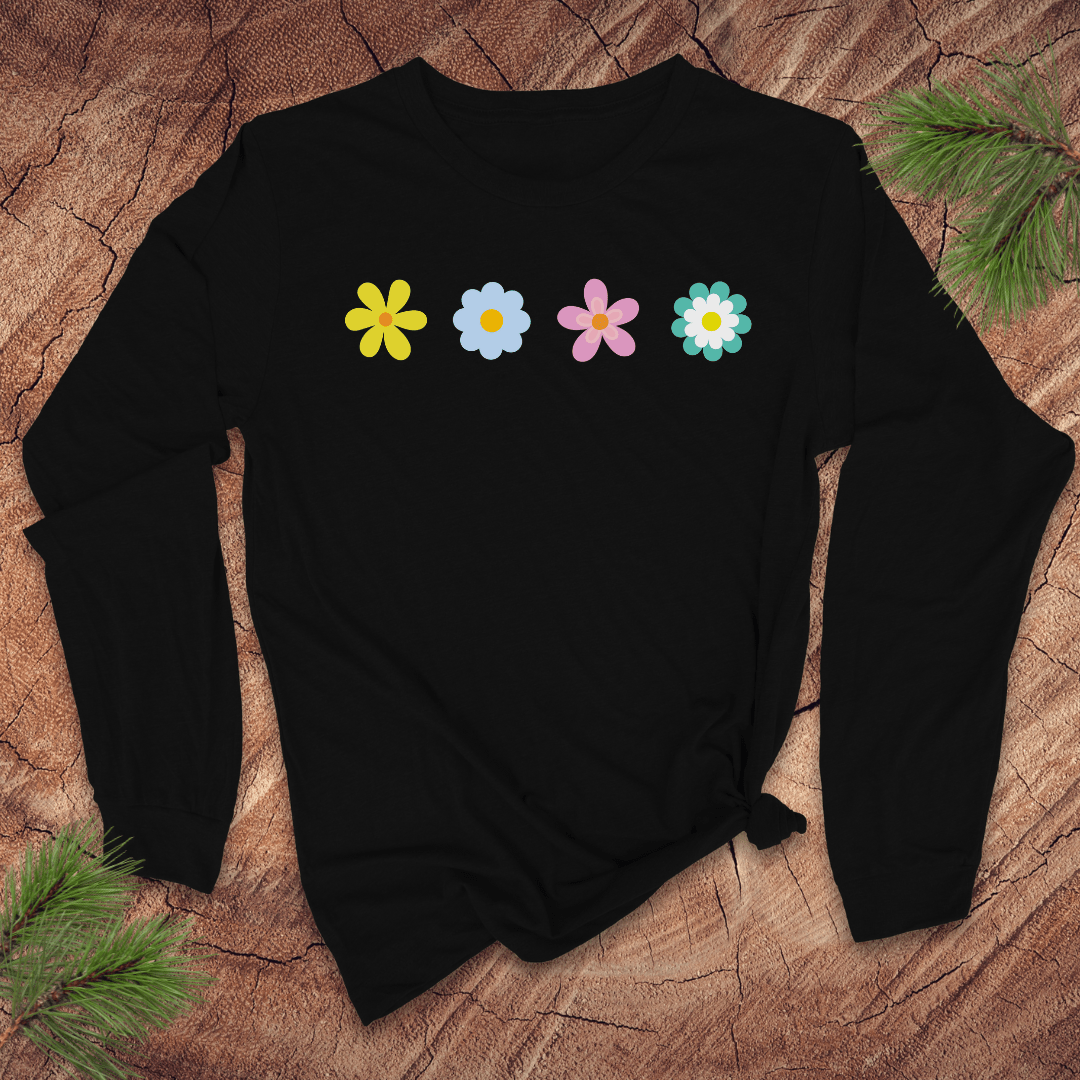 black  long-sleeve shirt with colorful flower designs on a wooden surface with pine branches