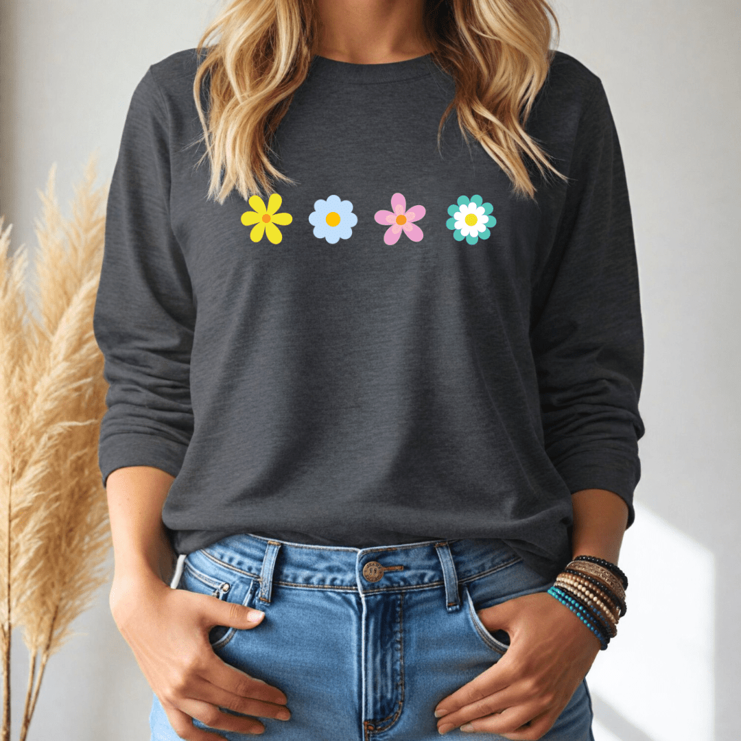 Person wearing a dark gray long sleeve tshirt with colorful flower designs and blue jeans.