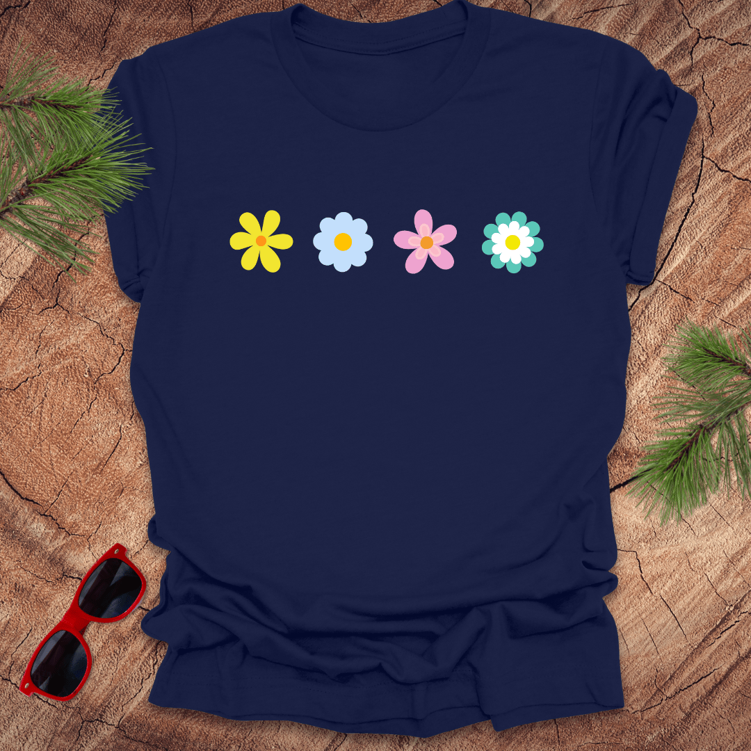 Navy blue t-shirt with colorful flower graphics on a wooden surface with sunglasses and greenery.