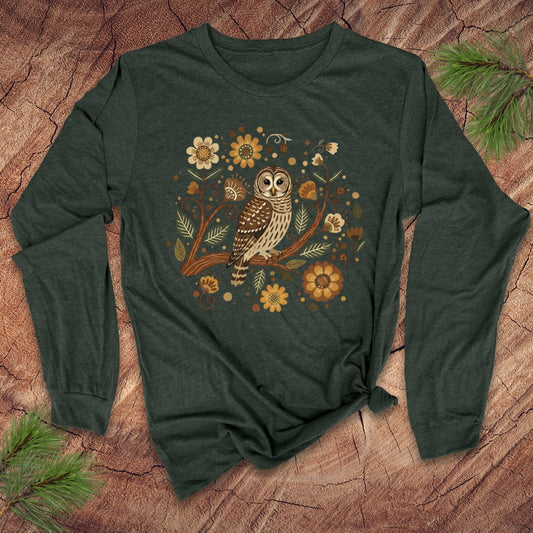 Green long-sleeve shirt with an owl and floral design on a wooden surface.