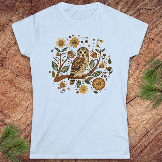 Light blue t-shirt with an owl and floral design on a wooden surface