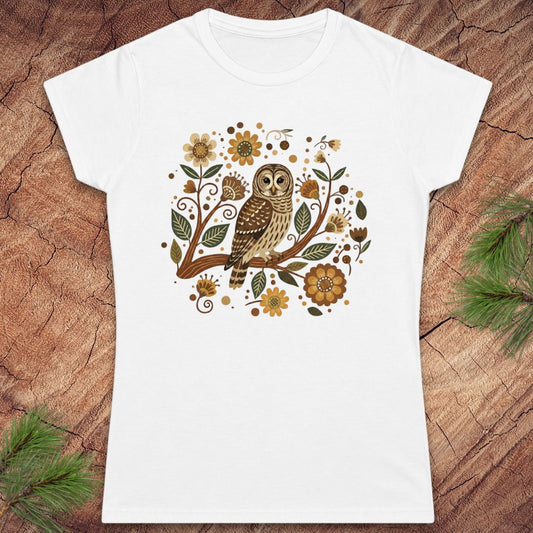 White t-shirt with an owl and floral design on a wooden surface