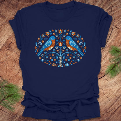 Navy blue t-shirt with a decorative design of two birds on a wooden surface.