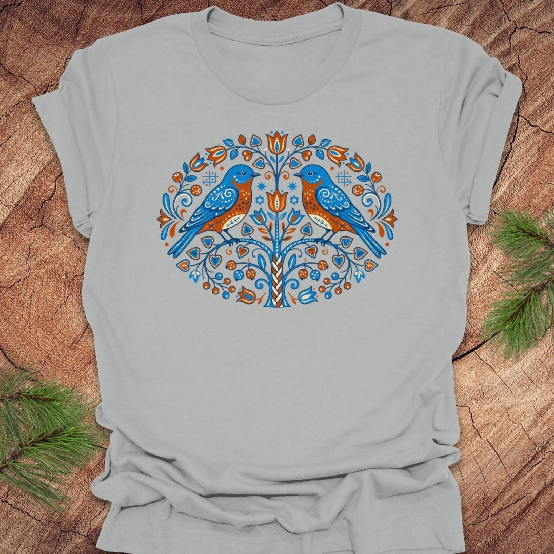 Gray t-shirt with blue bird design on a wooden surface