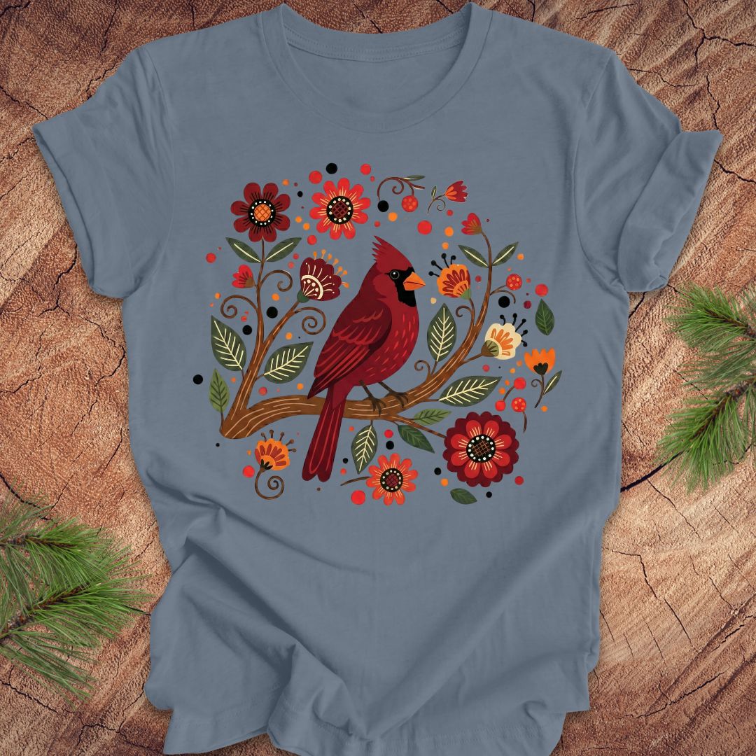 Blue t-shirt with a red cardinal and floral design on a wooden surface