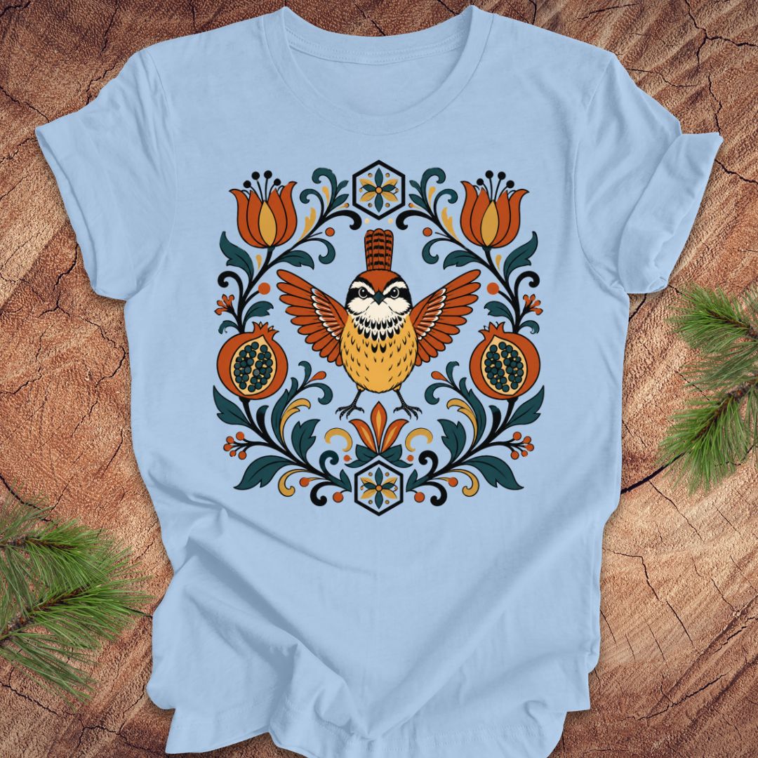 Light blue t-shirt with a carolina wren and floral design on a wooden surface