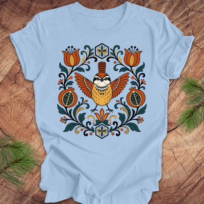 Light blue t-shirt with a carolina wren and floral design on a wooden surface
