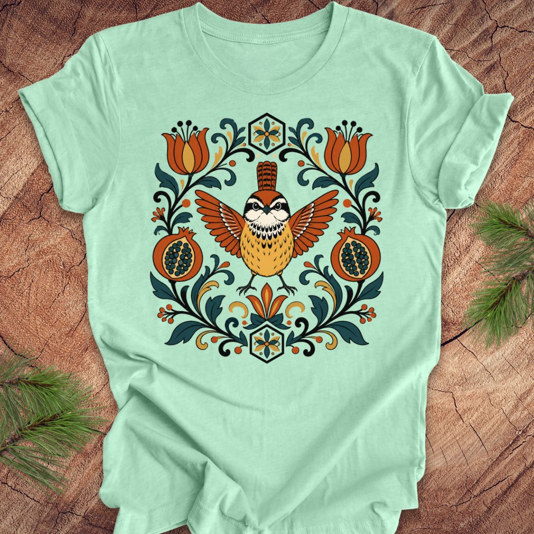 Mint green t-shirt with a carolina wren and floral design on a wooden surface