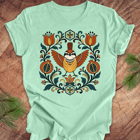 Mint green t-shirt with a carolina wren and floral design on a wooden surface