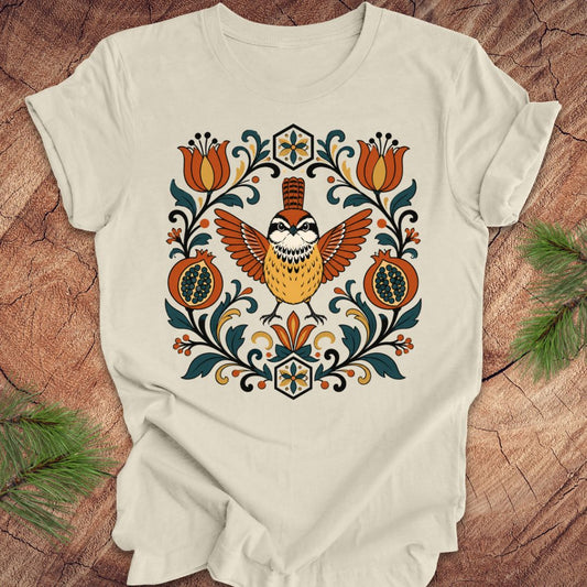 Beige t-shirt with a carolina wren and floral design on a wooden surface