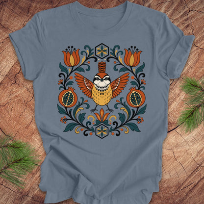 Blue t-shirt with a carolina wren and floral design on a wooden surface