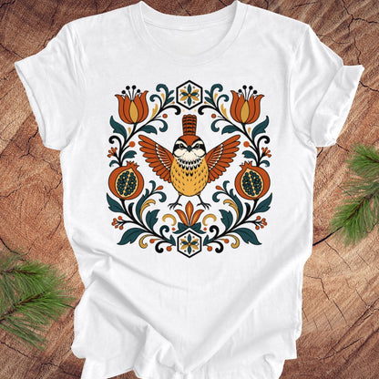 White t-shirt with a carolina wren and floral design on a wooden surface
