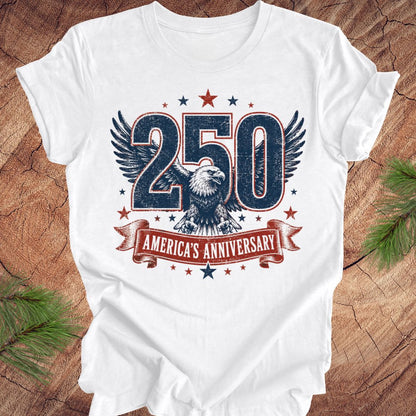 White t-shirt with '250 America's Anniversary' design featuring an eagle on a wooden surface.