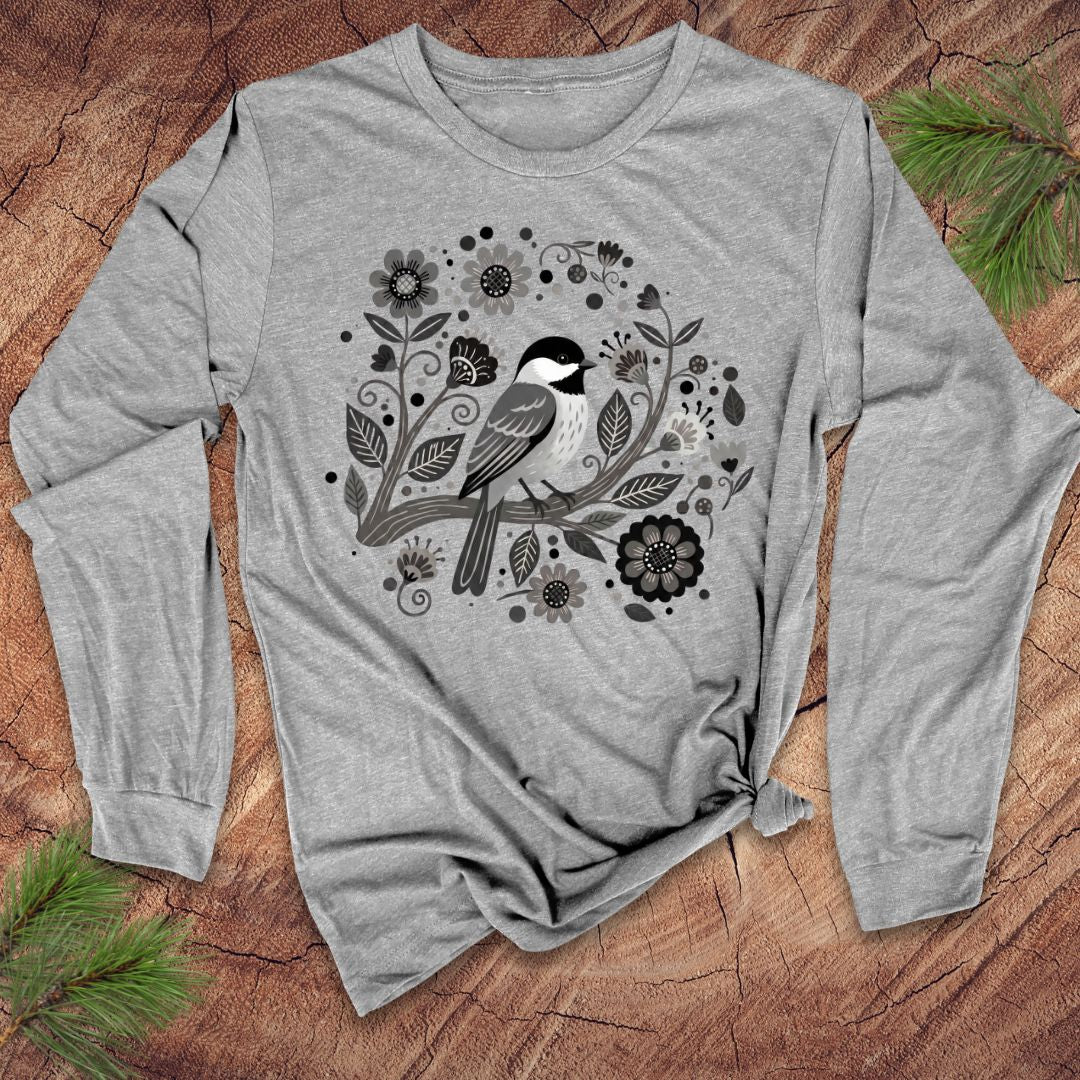 Gray long-sleeve shirt with a bird and floral design on a wooden surface