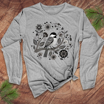 Gray long-sleeve shirt with a bird and floral design on a wooden surface