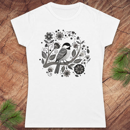 White t-shirt with a chickadee bird and floral design on a wooden surface