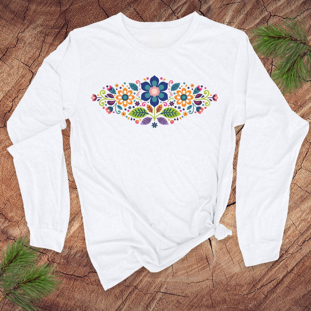 White long-sleeve t-shirt with a vibrant floral pattern in an oval shape, on a wooden background.