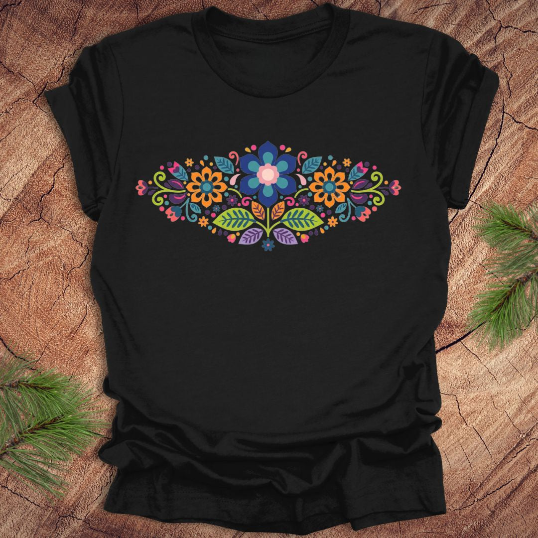 Black t-shirt with a vibrant floral pattern in an oval shape, on a wooden background.