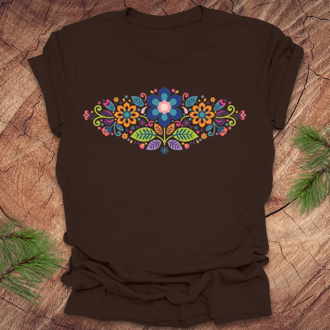 Brown t-shirt with a vibrant floral pattern in an oval shape, on a wooden background.