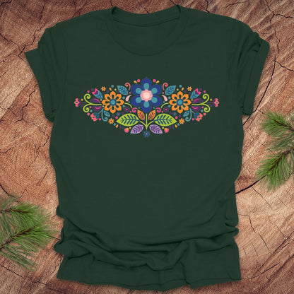 Forest green t-shirt with a vibrant floral pattern in an oval shape, on a wooden background.