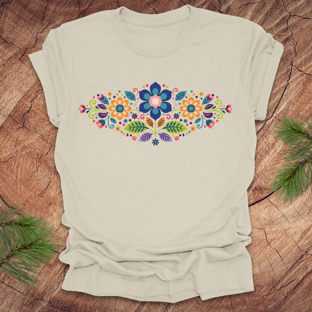 Beige t-shirt with a vibrant floral pattern in an oval shape, on a wooden background.