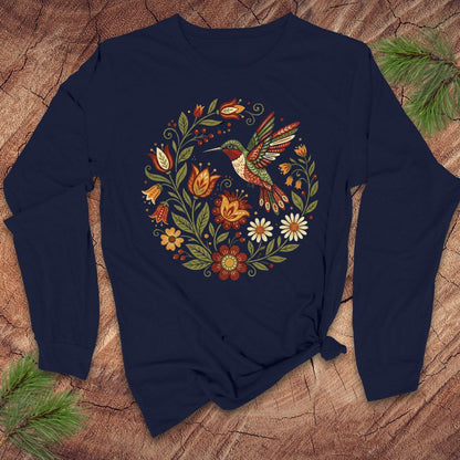 Navy blue long-sleeve tshirt with a colorful hummingbird and floral design on a wooden surface.