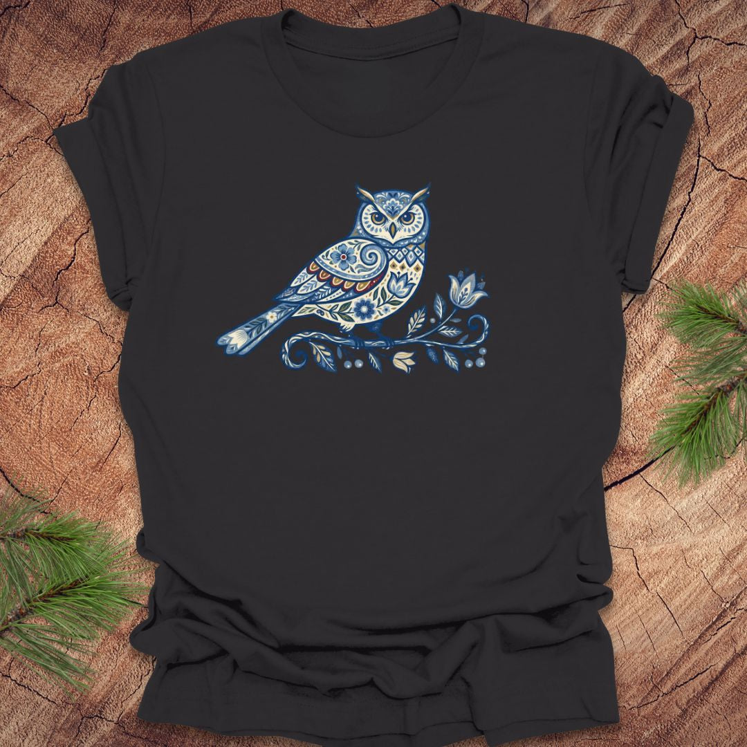 Dark gray t-shirt with a blue folk art floral owl design on a wooden surface