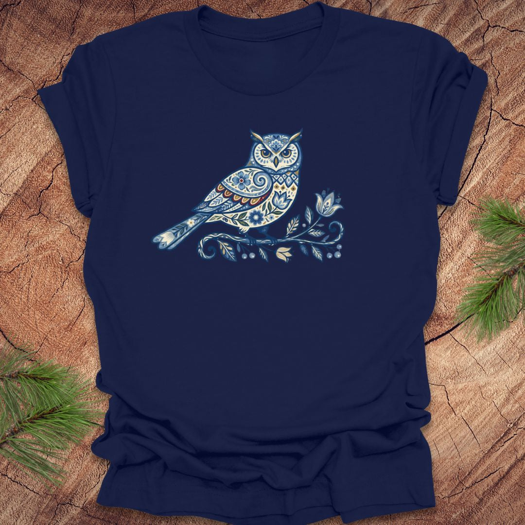 Navy blue t-shirt with a blue folk art floral owl design on a wooden surface