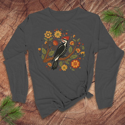 Dark gray long sleeve t-Shirt with a pileated woodpecker on a branch surrounded by folk art flowers on a wood background.