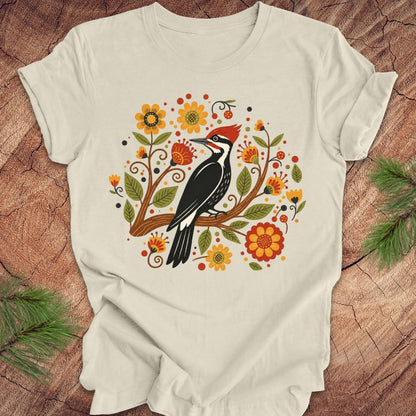 Beige t-shirt with a woodpecker design on a wooden surface